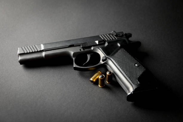 istock Pistol and traumatic bullets on black background. Self defense weapon 1253189738