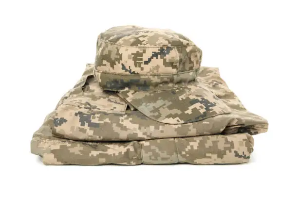 Folded military uniform and cap isolated on white background