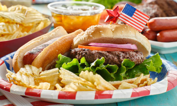 4 июля трапеза с гамбургером и хот-догом - hot dog hamburger burger grilled стоковые фото и изображения