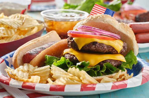 4th of july themed burger and hot dog meal on paper plate close up