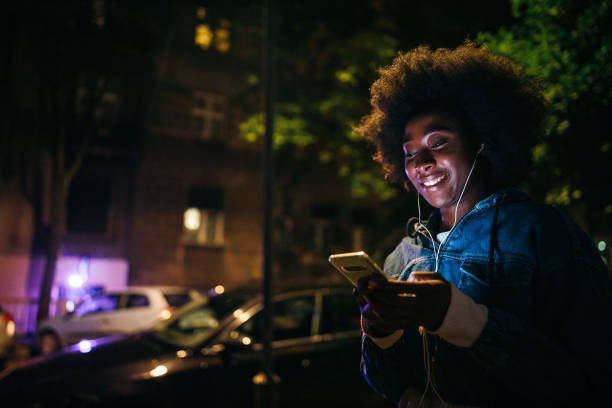 istock Young woman chatting online during night walk 1253196371