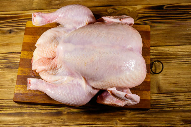 istock Raw whole chicken on a wooden table. Top view 1253201176