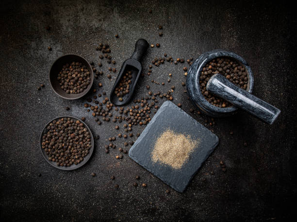Pile of ground black pepper. Black pepper in plates on dark background. Pile of ground black pepper. black peppercorn photos stock pictures, royalty-free photos & images