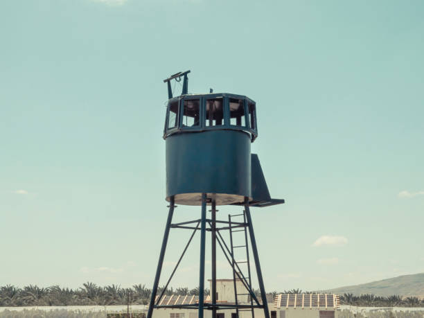 An old army guard metallic watchtower. In Kibbutz Degania, Israel. Banana plantation in the background and blue sky. Summer sunny day.