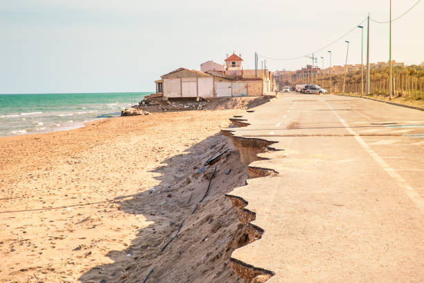 road near the beach collapsed by a sea storm. Climate change asphalt of the road cut by the waves in a sea storm eroded stock pictures, royalty-free photos & images