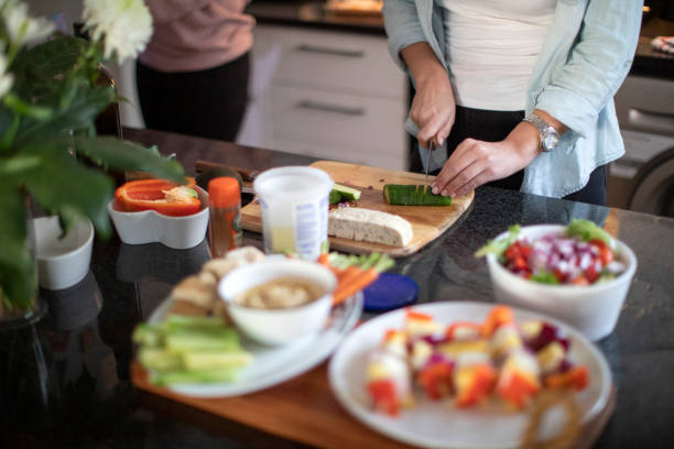 istock Two women having fun in the kitchen while making a healthy meal together for dinner with friends at home. 1253209791
