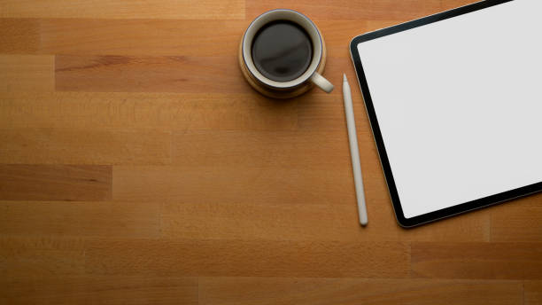 istock Blank screen tablet on wooden office desk with copy space and coffee cup 1253222390