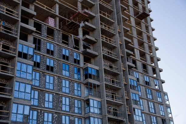 Installation of double-glazed windows in a multi-storey building at a construction site. Glazed window systems with uPVC frames. Housing Renovation Program
