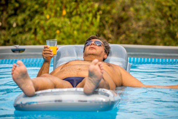 istock Funny fat guy in the pool. 1253222709