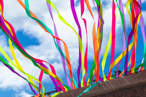 istock Bright multicolored ribbons on the wall develop against the sky, a view from below. 1253222741