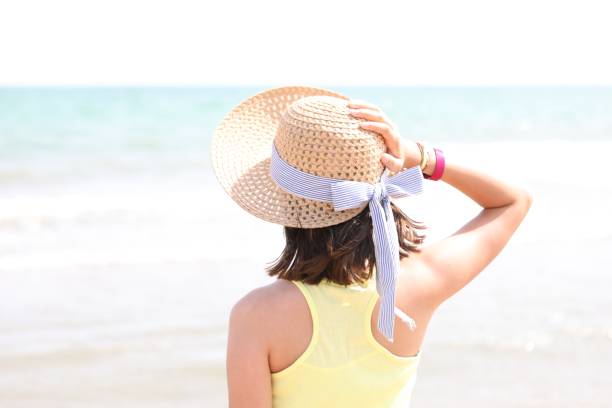 istock young girl on the seashore with straw hat and light tones 1253222907