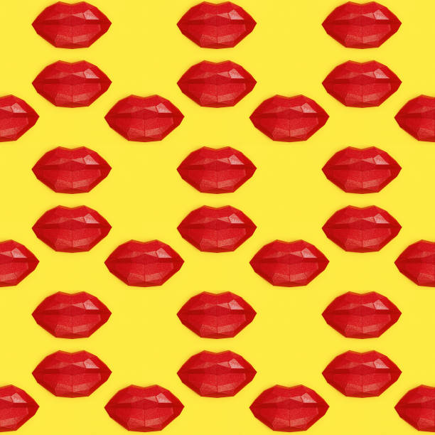 istock Seamless pattern with bright beauty red polygonal paper lips on yellow background. 1253224212