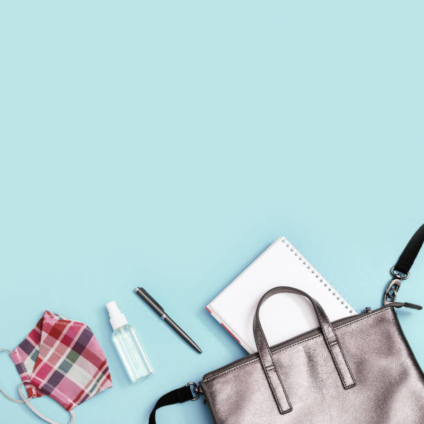 istock School bag and Personal protective equipments. Notebooks, pens, Face Shields and hand sanitizer on blue background with copy space. Top view. 1253224351