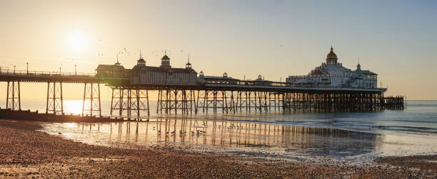 beau lever de soleil au-dessus de l’horizon de manche et de jetée d’eastbourne, east sussex, royaume-uni - horizon over water england uk summer photos et images de collection