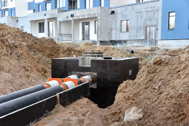 istock Laying heating pipes in a trench at construction site. Install underground storm systems of water main and sanitary sewer. Cold and hot water, heating and heating system of apartments in the house 1253224667