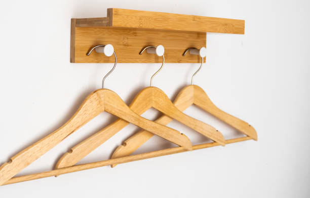 istock Clothes wooden hangers on a white wall. 1253229304