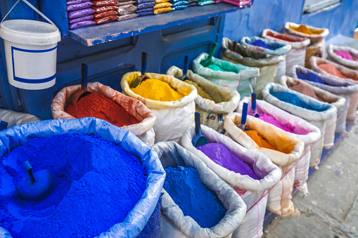 Colourful powdered pigments in sacks for sale in Chefchaouen. Blue city medina in Morocco with blue painted walls.