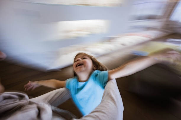 Joyful little boy having fun while having fun by his single parents at home. Blurred motion.