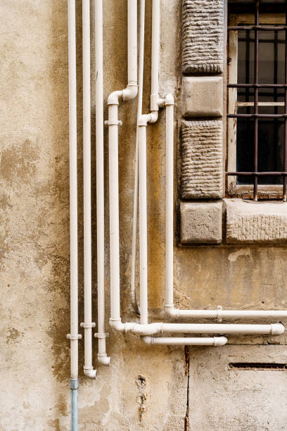 istock White plastic water pipes outside the building on the wall. 1253231219