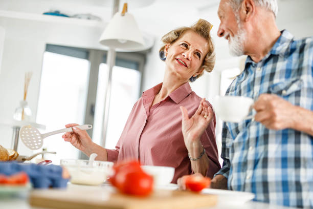 istock Happy senior couple talking while making breakfast in the morning. 1253231846