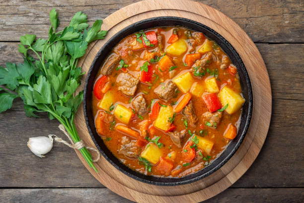 나무 테이블에 주철 팬에 고기, 야채와 향신료와 굴라쉬, 쇠고기 스튜 또는 bogrash 수프. - soup photography pan hungary 뉴스 사진 이미지