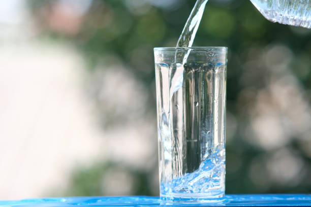 pouring sparkling water in a glass, isolated on black background