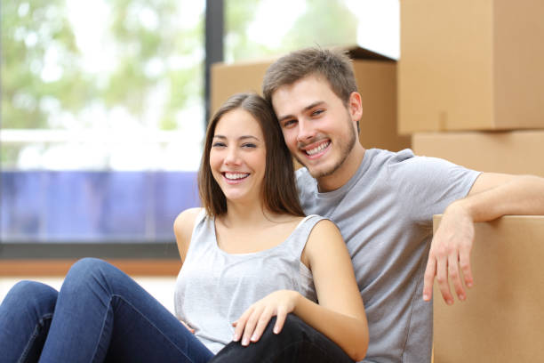 istock Happy couple moving looking at camera at home 1253232662