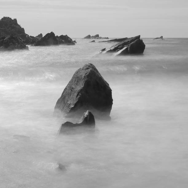 istock Rocks surrounded by blurred sea waves 1253232942