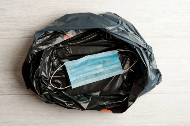 istock blue muzzle, inside garbage bag, wooden background. concept covid-19 1253234257