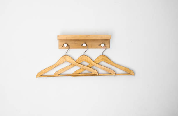 istock Clothes wooden hangers on a white wall. 1253234439