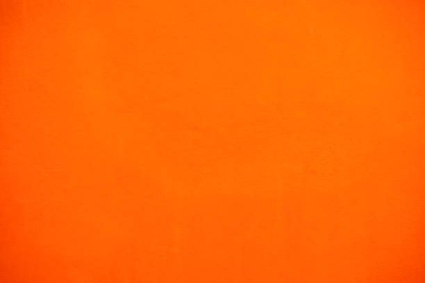 istock Concrete surfaces painted bright orange, abstract. Roughly polished plaster background wall decoration for orange background designers. 1253235672