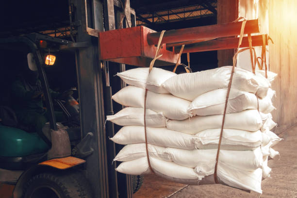 White sugar bags transferred to container for exporting. Forklift handling white sugar bag from warehouse for stuffing into container for export, vintage color. Forklift handling white sugar bag from warehouse for stuffing into container for export, vintage color. White sugar bags transferred to container for exporting. Forklift handling white sugar bag from warehouse for stuffing into container for export, vintage color. silo bag stock pictures, royalty-free photos & images