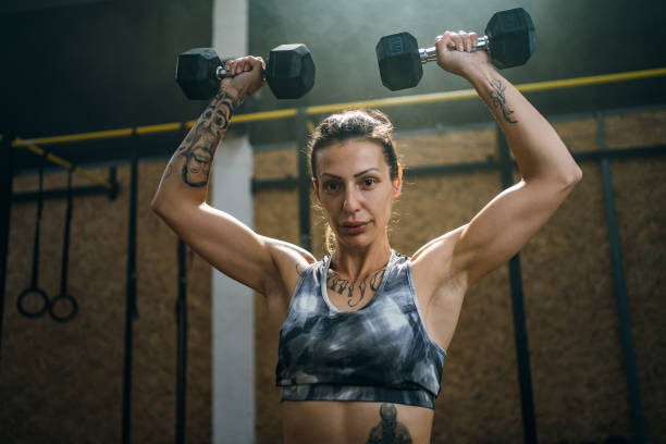 istock Young woman working out with dumbbell 1253235931