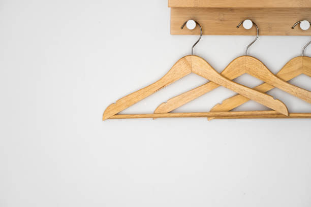 istock Clothes wooden hangers on a white wall. 1253236347
