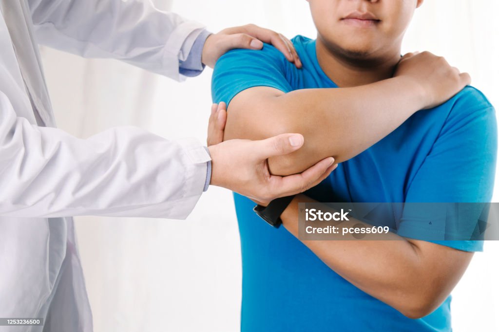 Doctor physiotherapist consulting with patient about elbow muscle pain problems.Physical therapy diagnosing concept Physical Therapy Stock Photo