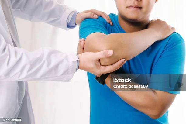 Doctor Physiotherapist Consulting With Patient About Elbow Muscle Pain Problemsphysical Therapy Diagnosing Concept Stock Photo - Download Image Now