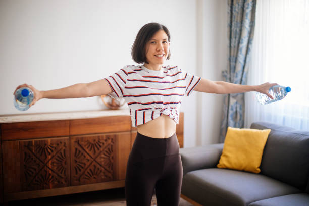istock Woman workout at home with water bottles 1253236531