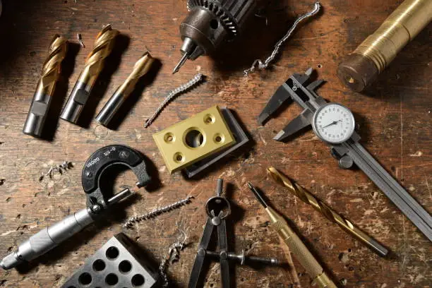 Louisville, CO, USA, June 28th, 2020: a handmade precision product is seen on a craftsman's workbench.  A part for a handmade robot is accompanied by tools of the trade to depict qualities of craftsmanship, artistry, care and uniqueness. The part was designed and fabricated by the photographer.