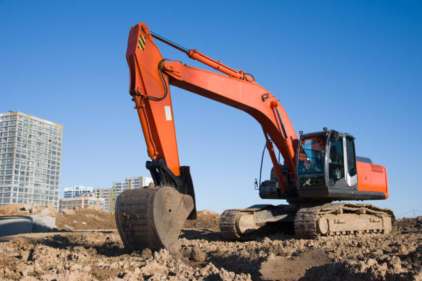 Excavator during earthmoving at construction site. Backhoe digg ground at construction site for the construction of the road and laying sewer pipes district heating. Earth-moving heavy equipment excavadora durante el movimiento de tierras en el sitio de construcción. terreno de digg retroexcavadora en el sitio de construcción para la construcción de la carretera y la colocación de tuberías de alcantarillado calefacción urbana. equipo pesado