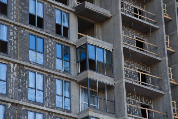 Installation of double-glazed windows in a multi-storey building at a construction site. Glazed window systems with uPVC frames. Housing Renovation Program