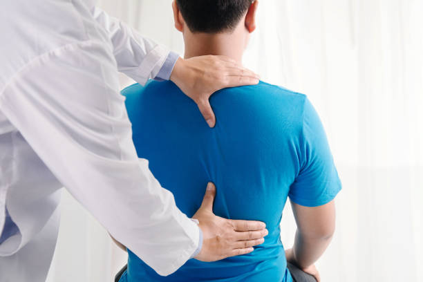 arzt physiotherapeut bei der heilung auf dem rücken des menschen. rückenschmerzen patient, behandlung, arzt, massage therapeut.office-syndrom - chiropraktische therapie stock-fotos und bilder