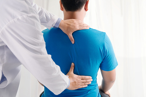 Fisioterapeuta doctora haciendo tratamiento curativo en la espalda del hombre. Paciente de dolor de espalda, tratamiento, médico, masajista.síndrome de la oficina photo