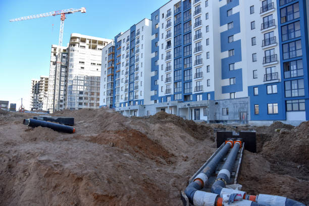 istock Laying heating pipes in a trench at construction site. Install underground storm systems of water main and sanitary sewer. Cold and hot water, heating and heating system of apartments in the house 1253238360