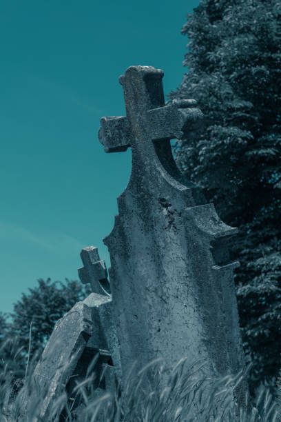 istock Old cross headstone on the graveyard 1253239717