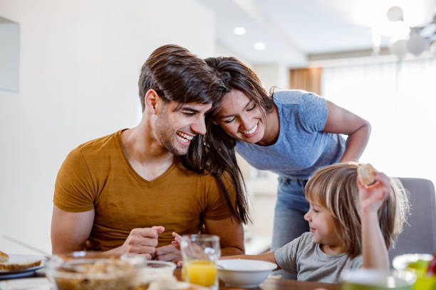 istock Young happy family having fun during breakfast in dining room. 1253239811