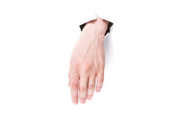 istock male hand hanging tired through a hole in paper on a white background isolate. close up, copy space. 1253240885
