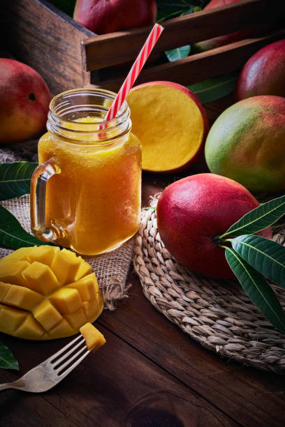 istock Mango smoothie juice and fruit in mason jar on wooden table in rustic kitchen 1253241962