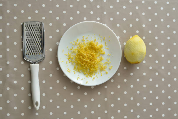 терка и плита со спелым лимоном и цедрой на столе - grater grated peel ingredient стоковые фото и изображения