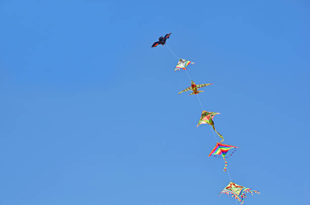 istock A colorful kite flying high in a deep blue sky. 1253242363