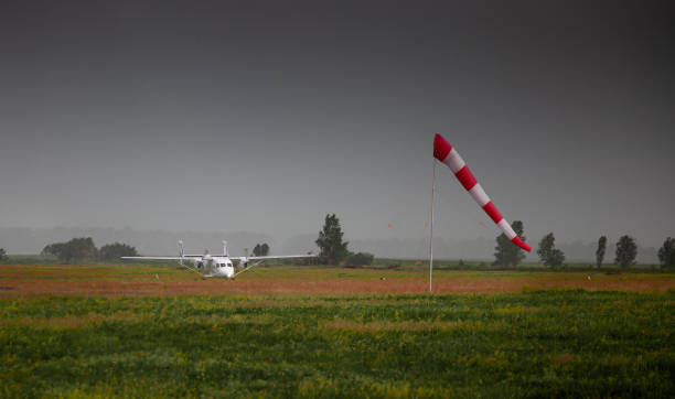 istock Windsock, weather vane for airfields. Red and white striped fabric showing wind speed, strength and direction. Umbrella cap at the airport. Wind cone - a fabric cone used in aviation. Outdoor 1253245310